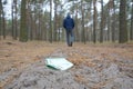 Young man loses his euro money bills on Russian autumn fir wood path. Carelessness and losing money concept Royalty Free Stock Photo