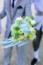 The young man is in love. Holding a white bouquet To give to a beloved wonan on green bokeh background Royalty Free Stock Photo