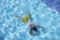 Young man lying on bottom of swimming pool top view