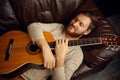 Young man lying on couch with guitar Royalty Free Stock Photo