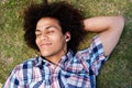 Young man lying down on grass listening to music Royalty Free Stock Photo