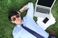 Young man lying on green lawn in park Royalty Free Stock Photo