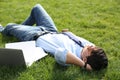 Young man lying on green lawn in park Royalty Free Stock Photo