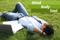 Young man lying on green lawn in park. Royalty Free Stock Photo