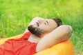 Young man lying on an inflatable mattress in the park