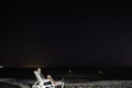 Young man lying over a beach chair watching a starry night at santa marta city beach Royalty Free Stock Photo