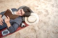 Young man lying on sandy beach and reading his notebook Royalty Free Stock Photo