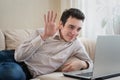 Young man lying on sofa and using laptop at home Royalty Free Stock Photo