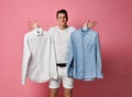 Young man makes a choice of a shirt. Blue or white? what choose? Royalty Free Stock Photo