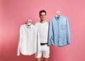 Young man makes a choice of a shirt. Blue or white? what choose? Royalty Free Stock Photo