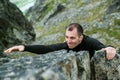 Young man makes hard climbing a steep rock without a rope. Rock-climb extreme sport. Tourist man hiking and climbing at mountains Royalty Free Stock Photo