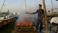 Young man prepares BBQ in large quantity