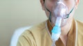 Young man making inhalation with nebulizer at the hospital. child asthma inhaler inhalation nebulizer steam. Sick cough and health Royalty Free Stock Photo