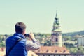 Young man making mobile camera photo of Cesky Krumlov landmark and architecture.