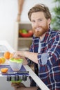 young man making orange juice in kitchen Royalty Free Stock Photo