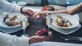 Young man is making proposal to girlfriend opening jewelry box then putting engagement ring on her finger and squeezing Royalty Free Stock Photo