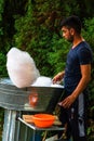 Young man making and selling cotton candy on an alley in the park at a festival in Bucharest, Romania, 2019 Royalty Free Stock Photo