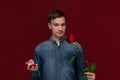 Young man making wedding proposal holding one red rose and box with engagement ring. Concept of love Royalty Free Stock Photo