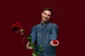 Young man making wedding proposal holding one red rose and box with engagement ring. Royalty Free Stock Photo