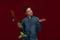 Young man making wedding proposal holding one red rose and box with engagement ring. Concept of love Royalty Free Stock Photo