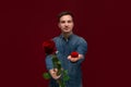 Young man making wedding proposal holding one red rose and box with engagement ring. Royalty Free Stock Photo
