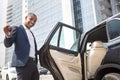 Young man manager standing with car door opened holding keys looking camera playful Royalty Free Stock Photo