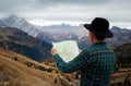 Young man with a map in the mountains. Hiking concept, lifestyle, traveler. Italian Alps, Dolomites Royalty Free Stock Photo
