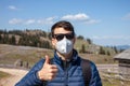 Young man in mask and sunglasses walking outside