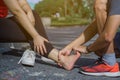 Young man massaging young woman on painful ankle. Suffering from ankle injury while exercising and running . Sport and exercise