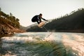 young man masterfully jump with foil wakeboard over splashing wave Royalty Free Stock Photo