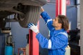 Young man is mechanic repair tires wheel car in the garage with professional, auto service, maintenance and technician.