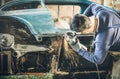 Young Man Mechanical Worker Repairing Old Vintage Car Body With
