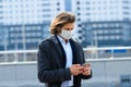 Young man in a medical mask outside, no money, crisis, poverty, hardship. Quarantine, coronavirus, isolation