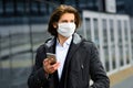 Young man in a medical mask outside, no money, crisis, poverty, hardship. Quarantine, coronavirus, isolation