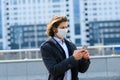 Young man in a medical mask outside, no money, crisis, poverty, hardship. Quarantine, coronavirus