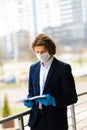 Young man in a medical mask outside, no money, crisis, poverty, hardship. Quarantine, coronavirus, isolation