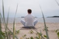 Young man meditating at the sea. Rear view Royalty Free Stock Photo