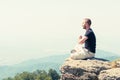 Young man meditating on top of the mountain Royalty Free Stock Photo