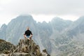 Young man meditating yoga at top of mountain. Concept travel and harmony with nature. Royalty Free Stock Photo