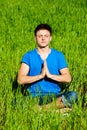 Young man meditation on green grass Royalty Free Stock Photo