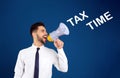 Young man with megaphone and text TAX TIME on background Royalty Free Stock Photo