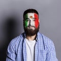 Young man with Mexica flag painted on his face