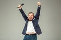 Young man with microphone on gray background, leading with microphone Royalty Free Stock Photo