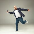 Young man with microphone on gray background, leading with microphone Royalty Free Stock Photo