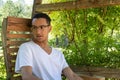 Young man mixed race looking away, backyard swing with greenery Royalty Free Stock Photo