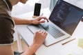Young man mobile developer, programmer writes program code on a laptop Royalty Free Stock Photo