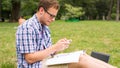 Young man with mobile phone sitting on a grass.