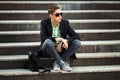 Young man with a mobile phone sitting on the steps Royalty Free Stock Photo