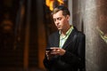 Young man with a mobile phone standing at the wall Royalty Free Stock Photo