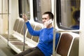 Young man on mobile phone in subway train Royalty Free Stock Photo